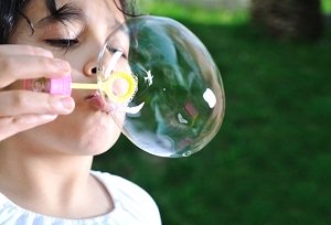 child blowing bubbles